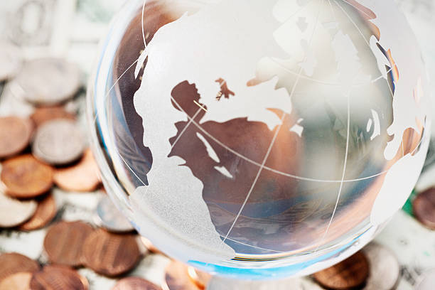 istock Glass globe, the Americas uppermost, resting on coins 187536916