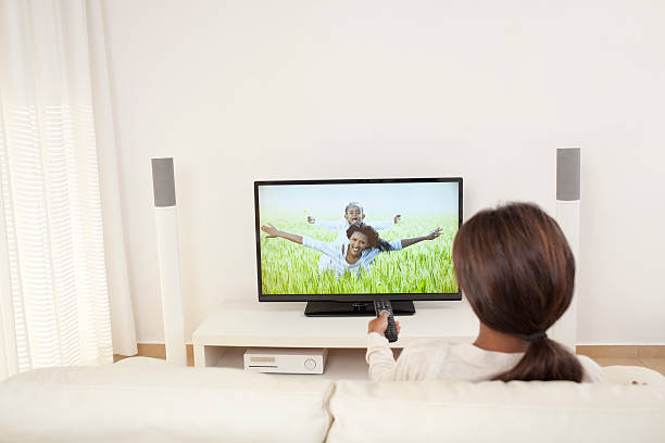 Woman watching TV at home in living room. stock photo
