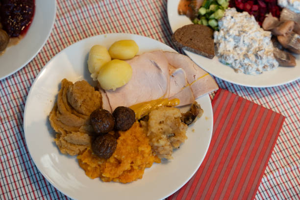 Christmas dinner table with cooked fish, drinks and Christmas tree background