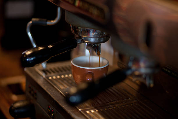 Fresh espresso pouring into cup - horizontal stock photo