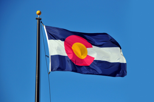 Flag of Colorado waving in the wind against blue sky - photo by M.Torres
