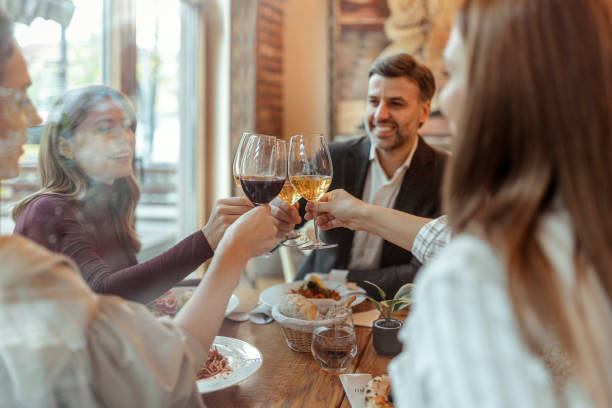 istock Friends Toasting Wine Glasses at Dinner Party 1875446011