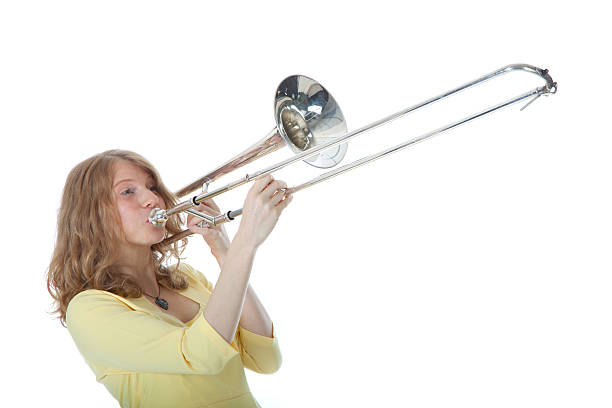 istock young woman in yellow with trombone 187546150
