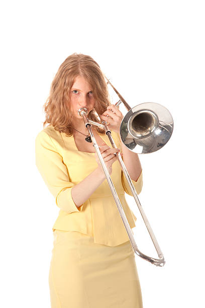 istock young woman in yellow playing trombone 187546215