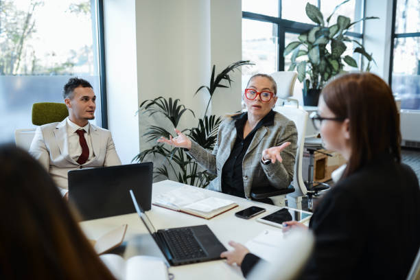 istock Female Company CEO Asking Younger Managers For Ideas While Working 1875467376