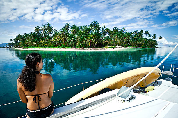 Sailing boat anchored in front of a beautiful palm tree island