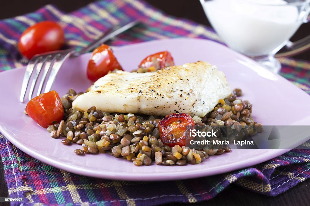 White fish fillet of perch, cod with vegetables and lentils Fried fish fillet of perch, cod with vegetables and lentils, tomatoes, homemade dinner Salad Stock Photo