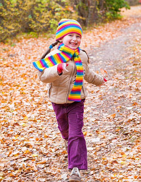 istock girl runs in autumn park 187551330