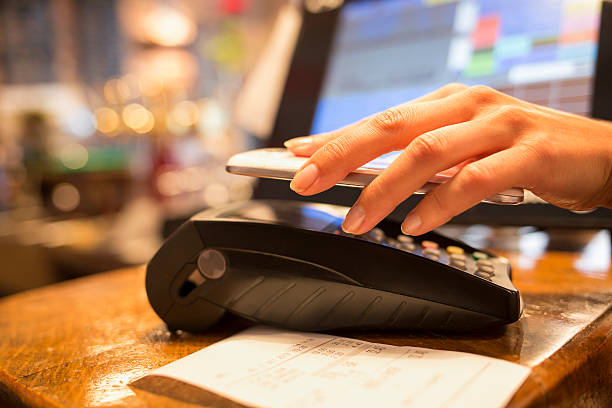femme payant avec technologie nfc sur téléphone mobile dans le restaurant - digital wallet photos et images de collection
