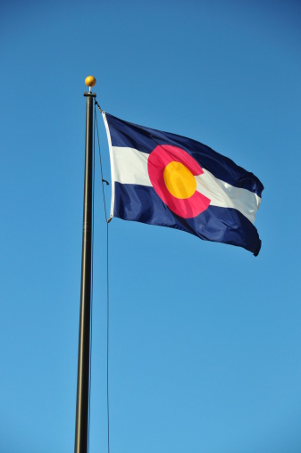 Lone Tree, Colorado, USA: flag of Colorado waving in the wind against blue sky - photo by M.Torres