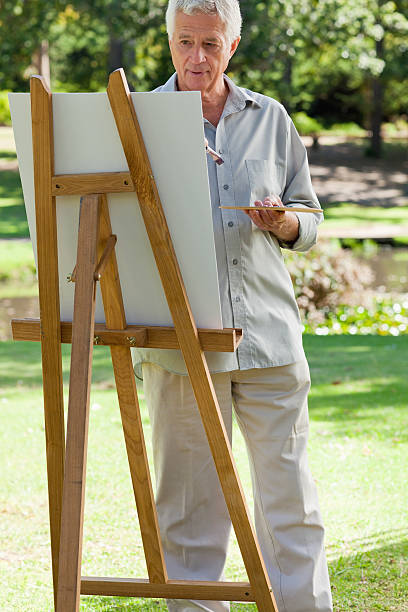 istock Old man painting on canvas in the sunshine 187553856