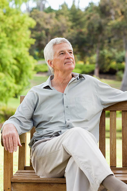 istock Elderly man looking up and relaxing on outdoor bench 187554456