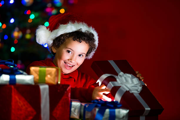 istock Excited child opening a gift under the Christmas tree 187556976