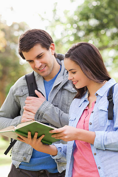istock Cute student showing a book to his buddy 187557233