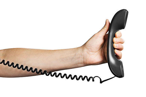 istock Black telephone receiver in outstretched hand with cord 187557238
