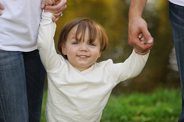 istock Family Holding Toddlers Hands 187559755