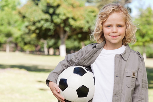 istock Boy smiling while holding a football 187560146