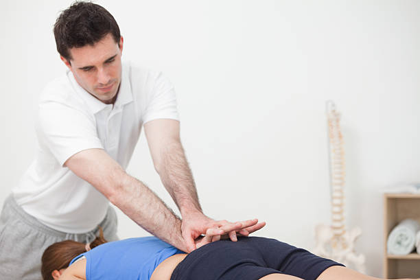 istock Practitioner pressing the lower back of woman while standing in 187561455