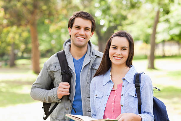 istock Portrait of a smiling student holding book with his buddy 187561546