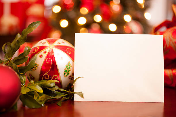 Close-up of blank greeting card among Christmas decorations on beige background