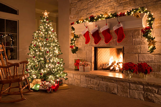 Christmas stockings, fireplace, tree, and decorations Christmas tree, and stockings hanging from mantel by fireplace.Waiting for Santa. red poinsettia vibrant color flower stock pictures, royalty-free photos & images