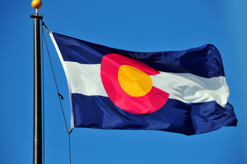 flag of Colorado waving in the wind against blue sky - photo by M.Torres