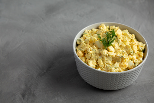 Homemade Egg Salad with Dill in a Bowl, side view. Space for text.