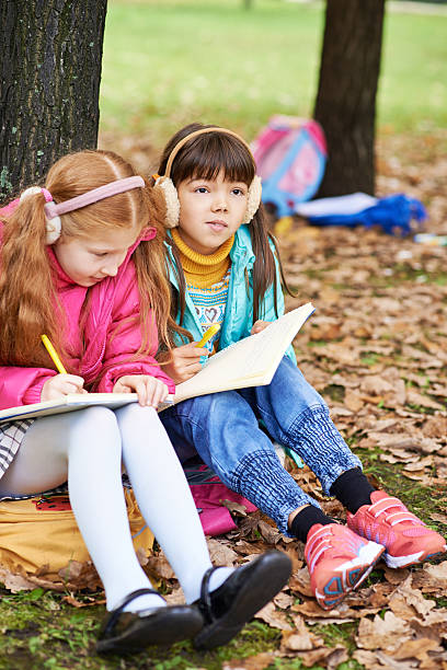 istock Little girl copies another child's notes 187564718