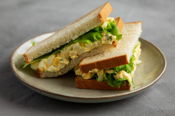 istock Homemade Egg Salad Sandwich with Lettuce on a Plate, side view. 1875653150