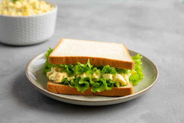 istock Homemade Egg Salad Sandwich with Lettuce on a Plate, side view. 1875653162
