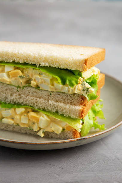 istock Homemade Egg Salad Sandwich with Lettuce on a Plate, side view. 1875653671