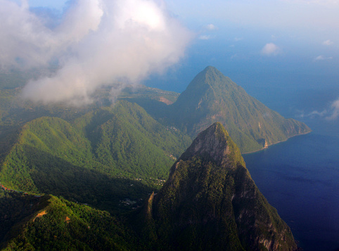 Castries, Saint Lucia, Windward Islands: Gros Piton (top) and Petit Piton (bottom) from the air - The Pitons Management Area is an area in the southwest of the island of St. Lucia, a few kilometers south of the town of Soufrière. The protected area includes: the Caldera Qualibou with several later volcanic domes and the two cooled volcanic cores , the 770 and 743 m high Pitons, a geothermal field with sulfur fumaroles and thermal springs ( Sulfur Springs ) as well tropical rainforest, subtropical rainforest, dry forest depending on the altitude zone and a marine area with species-rich coral reefs. UNESCO World Heritage Site.