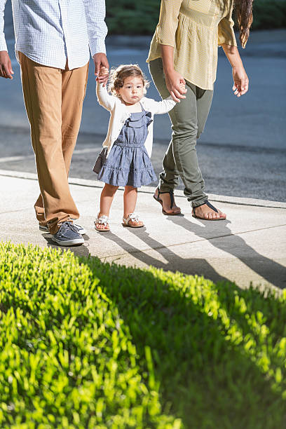 латиноамериканцы малыш ходьба с родителями - young family family with one child walking learning стоковые фото и изображения