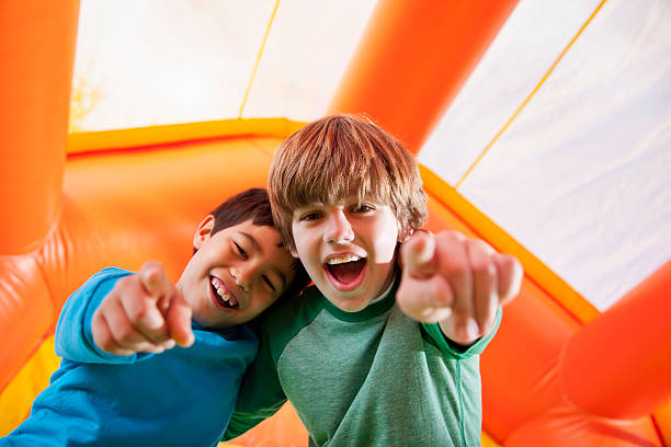 jungen in bounce house - house bouncing multi colored outdoors stock-fotos und bilder
