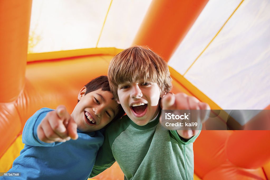 Boys in bounce house Multi-ethnic boys having fun in bouncy castle. Bouncy Castle Stock Photo