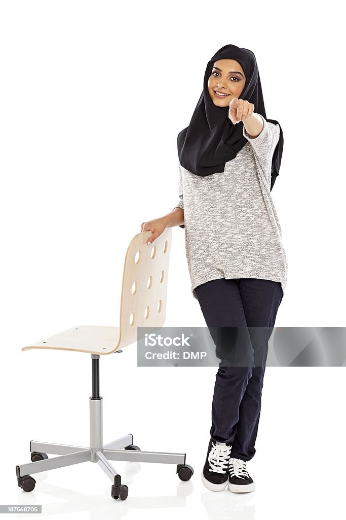 Femme musulmane avec une chaise, pointant à la caméra - Photo de 20-24 ans libre de droits