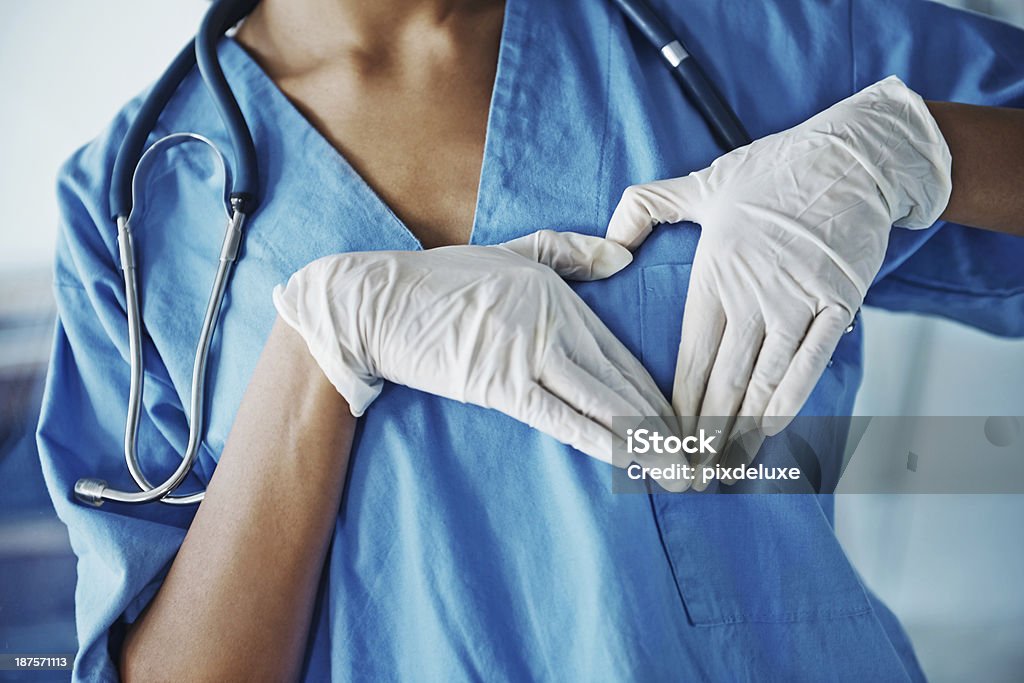 Showing where your heart lies Cropped image of a surgeon's chest while she makes the shape of a heart with her hands Adult Stock Photo