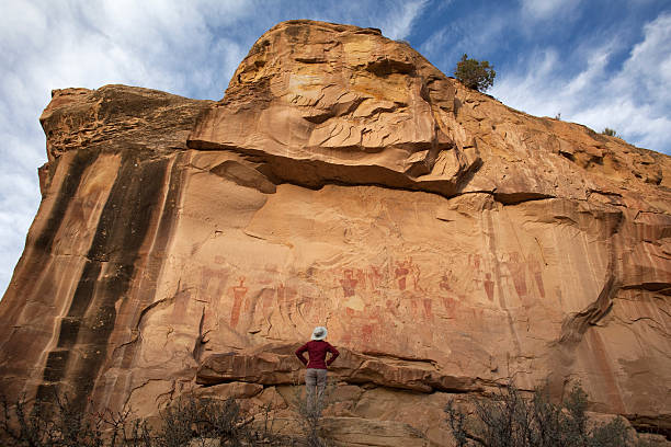 istock Woman admires Book Cliffs rock art pictograph panel Utah 187571485