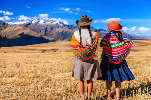 Peruvian women in national clothing crossing field, The Sacred Valley