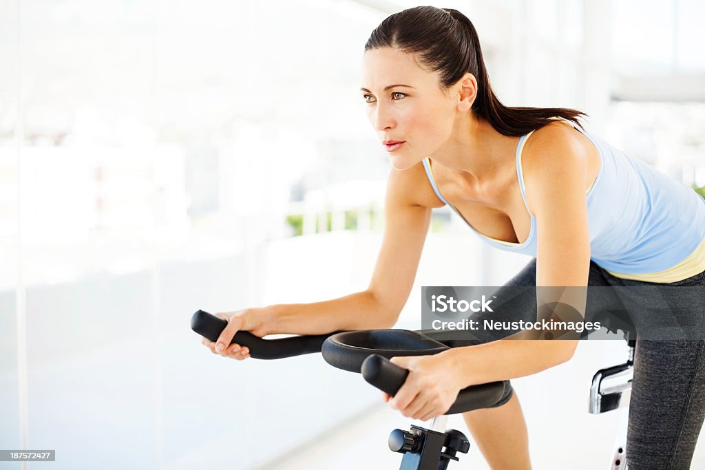 Frau Wegsehen beim Training auf dem Fahrrad im Fitness-Center - Lizenzfrei Heimtrainer Stock-Foto