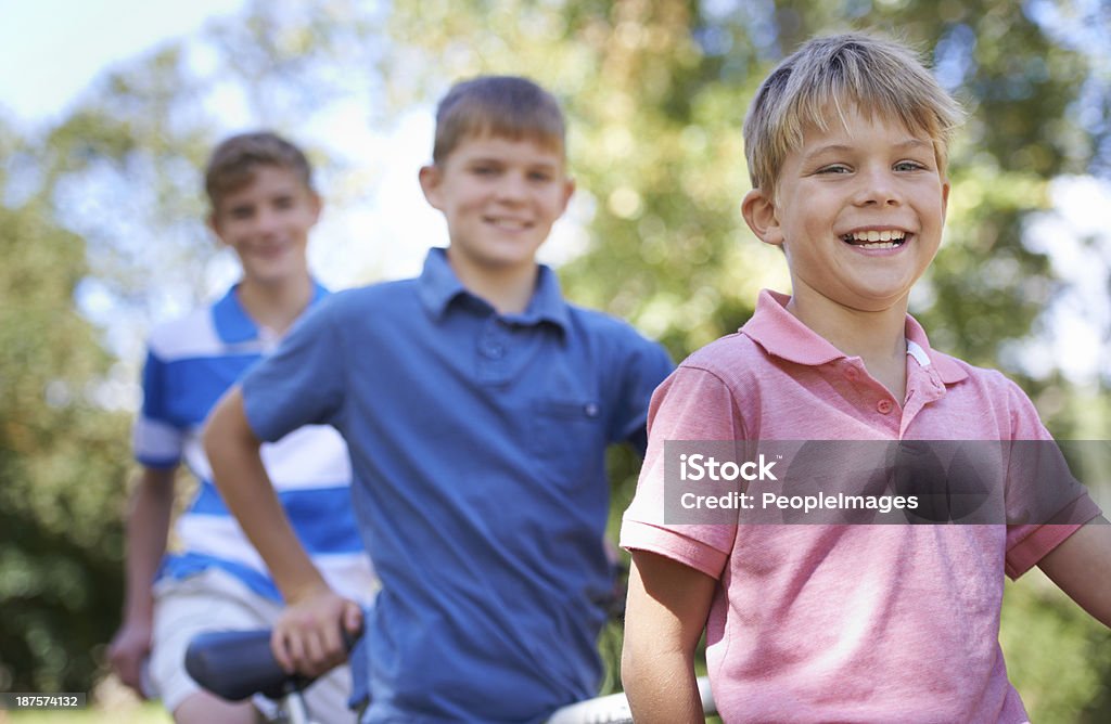 Out for an awesome bike ride! Three brothers out for a bike ride in the forest together Activity Stock Photo