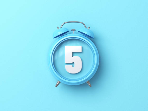 istock Number Five Sitting Over Blue Alarm Clock On Blue Background 1875741570