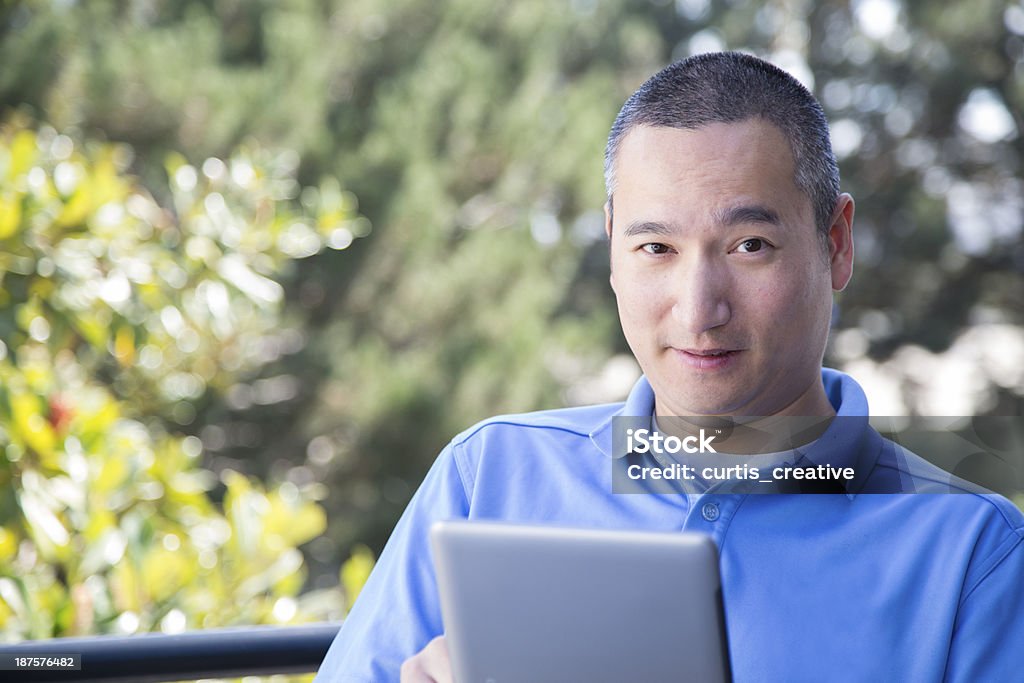 Asian idoso lendo livro em Tablet - Foto de stock de Azul royalty-free