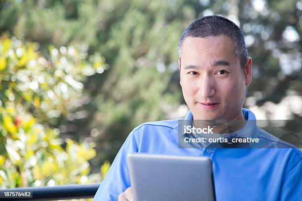 Foto de Asian Idoso Lendo Livro Em Tablet e mais fotos de stock de Azul - Azul, Camisa Pólo, 30-34 Anos