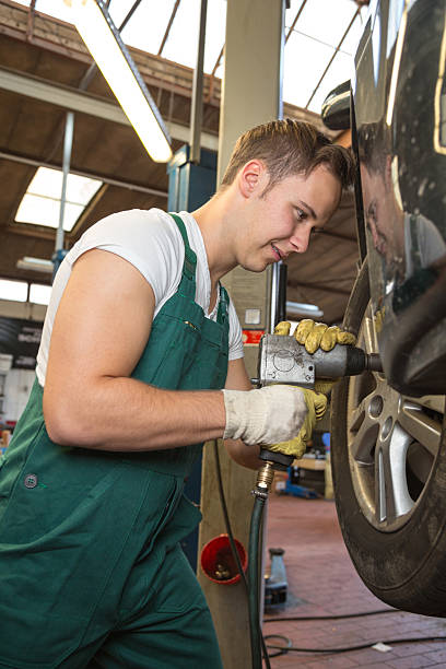 istock Mechanic replacing the tire or wheel on car in garage 187577309