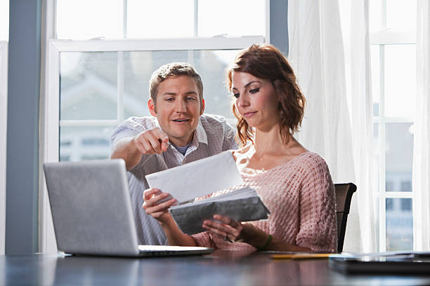 Home finances Happy couple at home paying bills.  Focus on man (20s). Sc0601 stock pictures, royalty-free photos & images