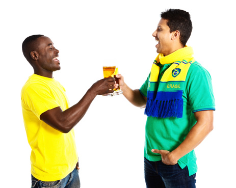 Two men dressed in Brazilian colors clink their beer glasses in a happy toast to their team for the 2014 Soccer World Cup in Brazil.