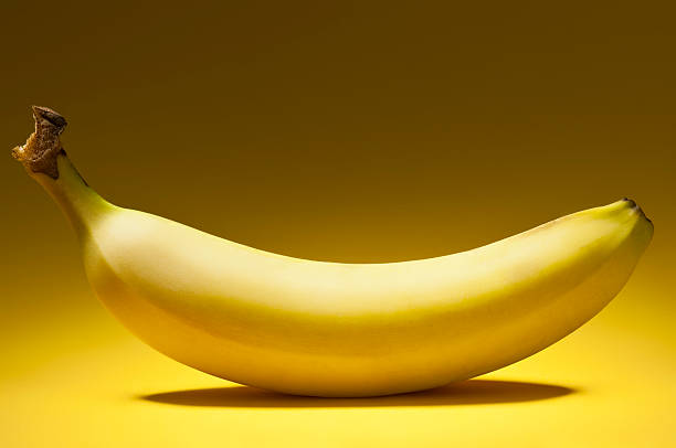 istock One yellow banana on yellow graduated background 187579588