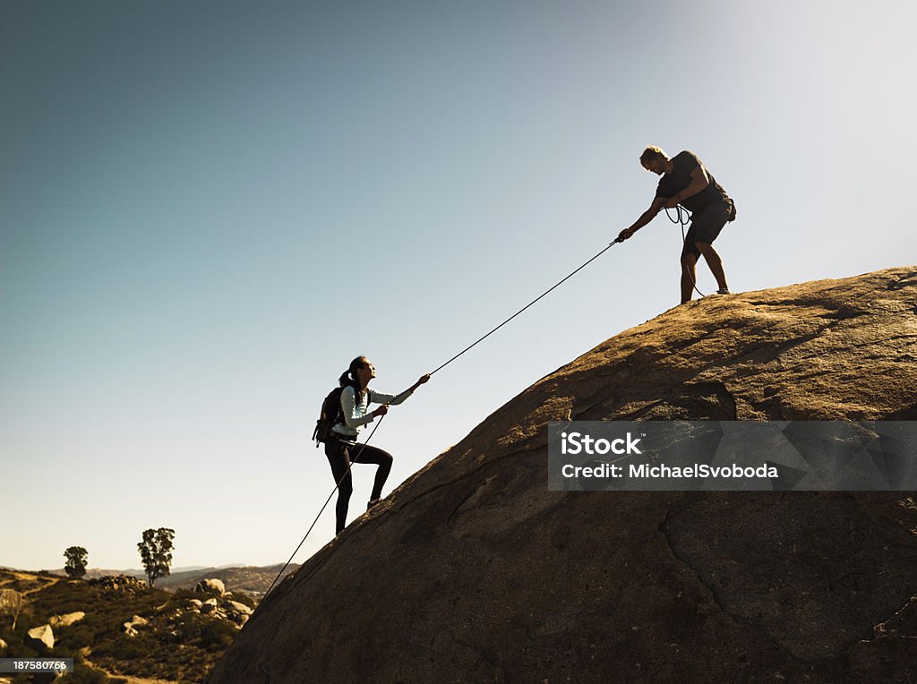 Helping Friends A man hekping his partner to the top. A Helping Hand Stock Photo