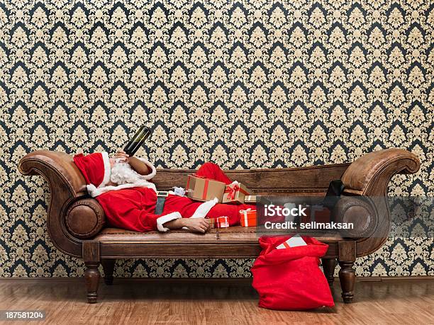 Borracho Santa Claus Abajo En El Sofá Bebiendo Vino Foto de stock y más banco de imágenes de Beber